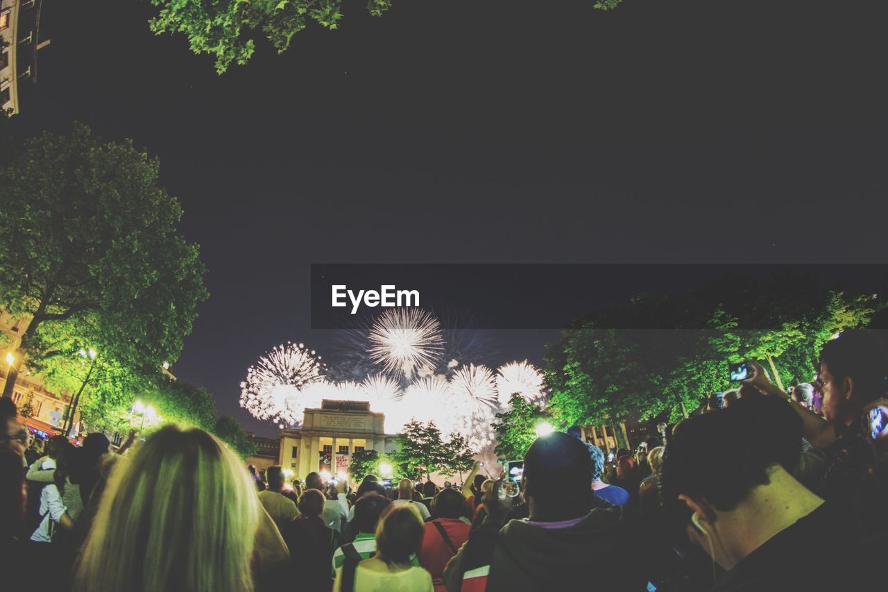 Crowd of people looking at fireworks at night