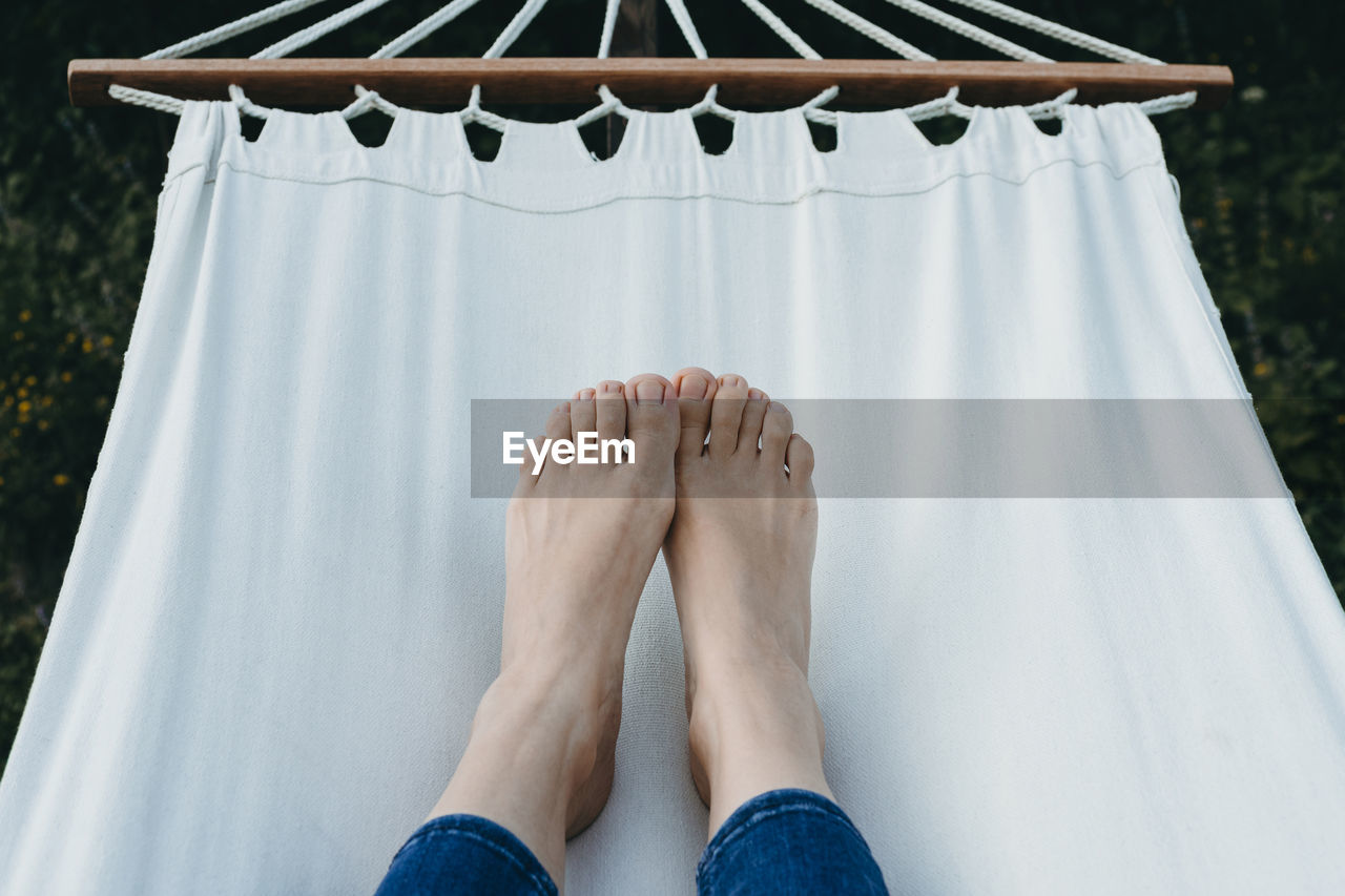 Low section of woman lying on hammock