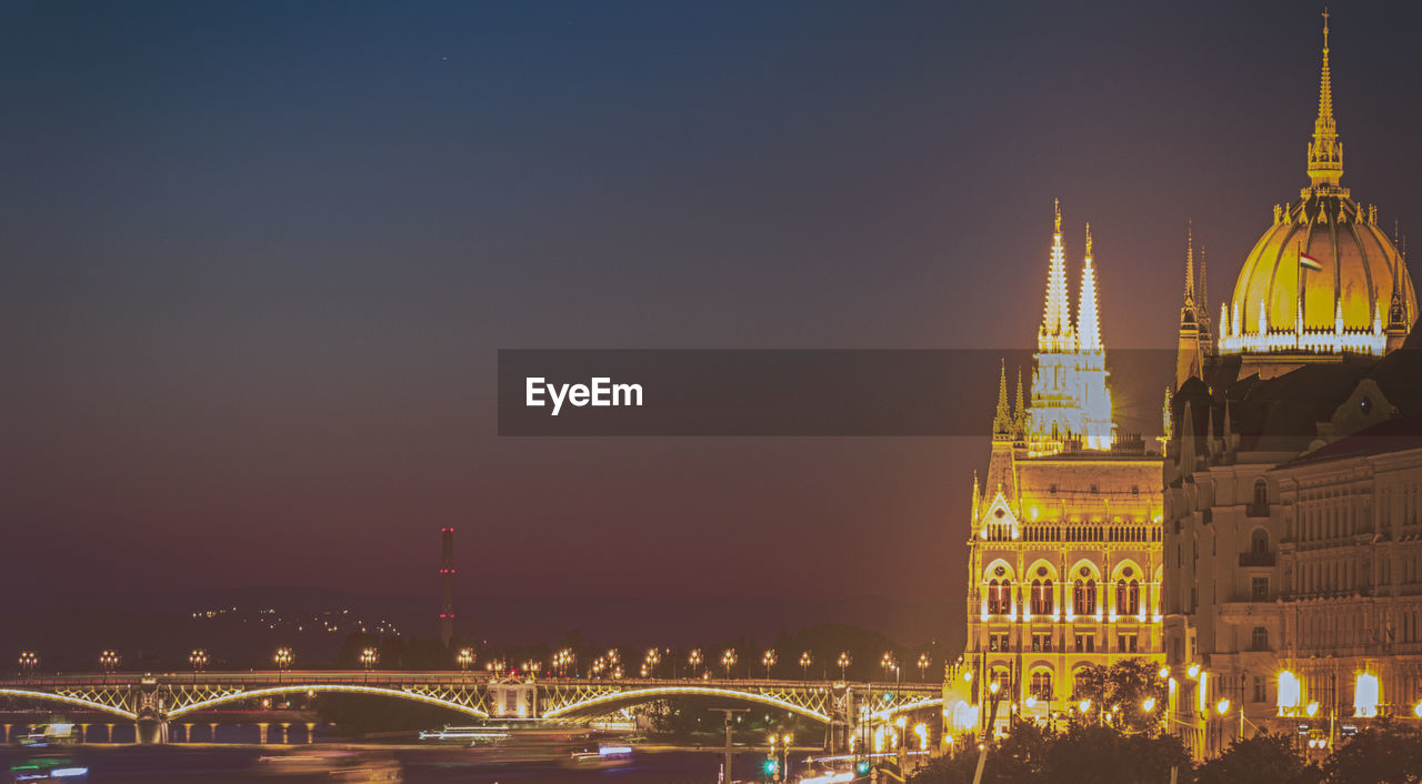 ILLUMINATED CITYSCAPE AGAINST SKY AT NIGHT