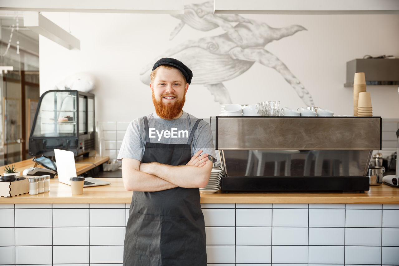 portrait of young man standing in kitchen