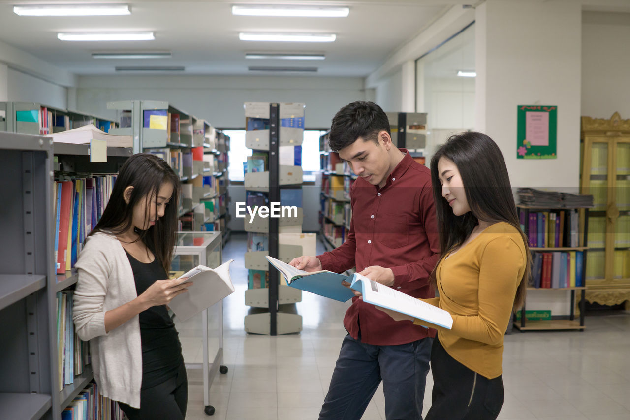 Students studying while standing in library