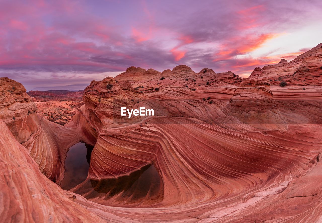 Scenic view of rock formations against cloudy sky