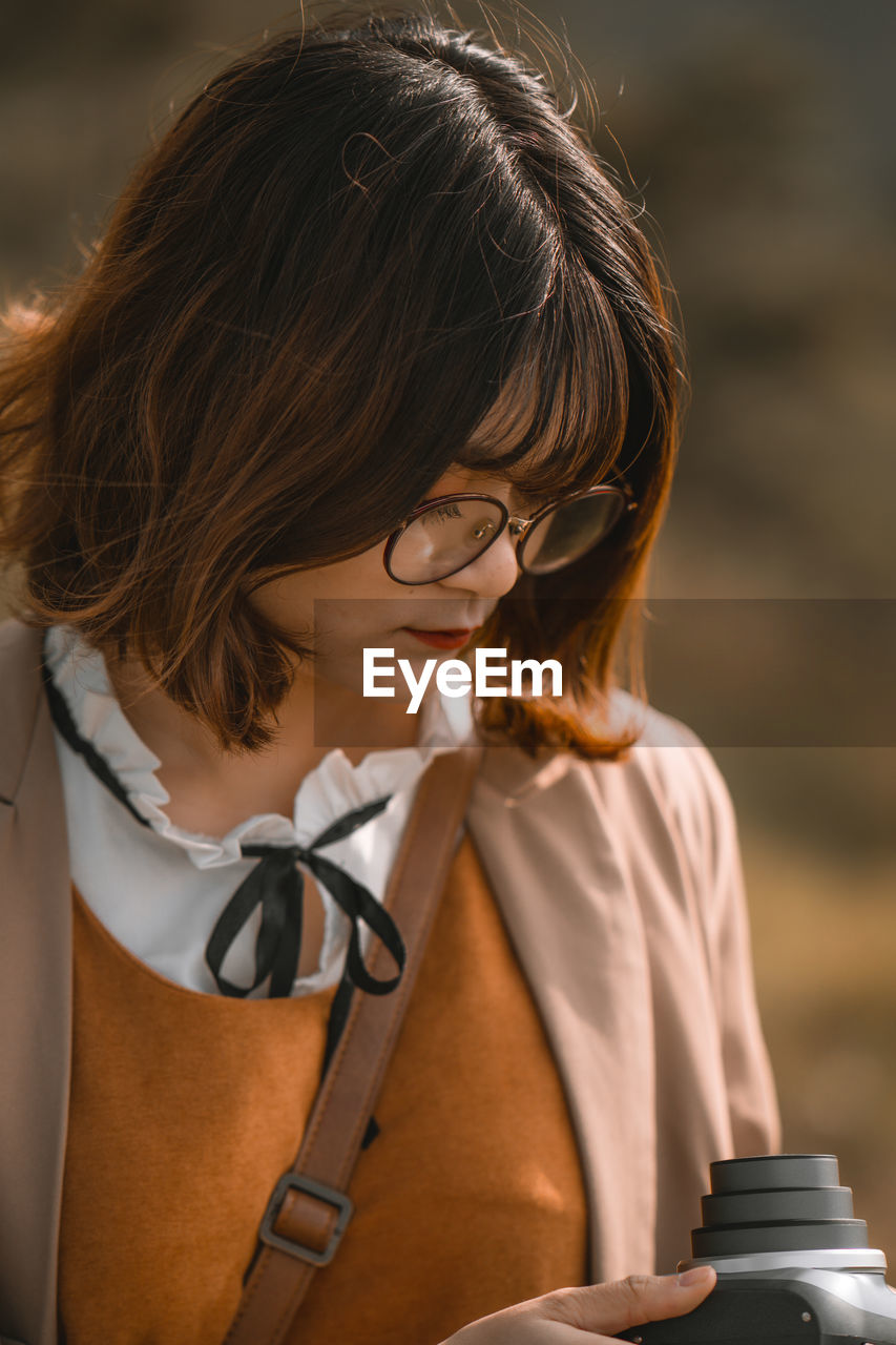 Close-up of woman using camera