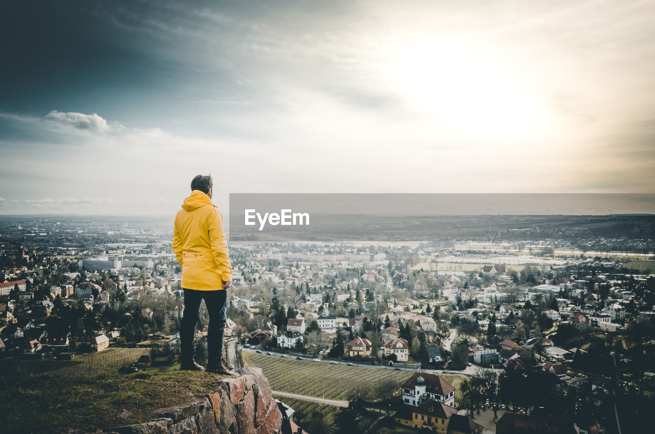 Rear view of a man overlooking cityscape