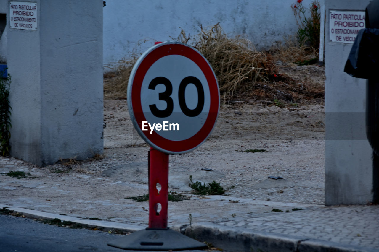 communication, sign, road sign, red, road, traffic sign, blue, warning sign, no people, street, day, guidance, stop sign, urban area, nature, geometric shape, city, circle, signage, information sign, text, shape, outdoors, architecture, snow, transportation, forbidden