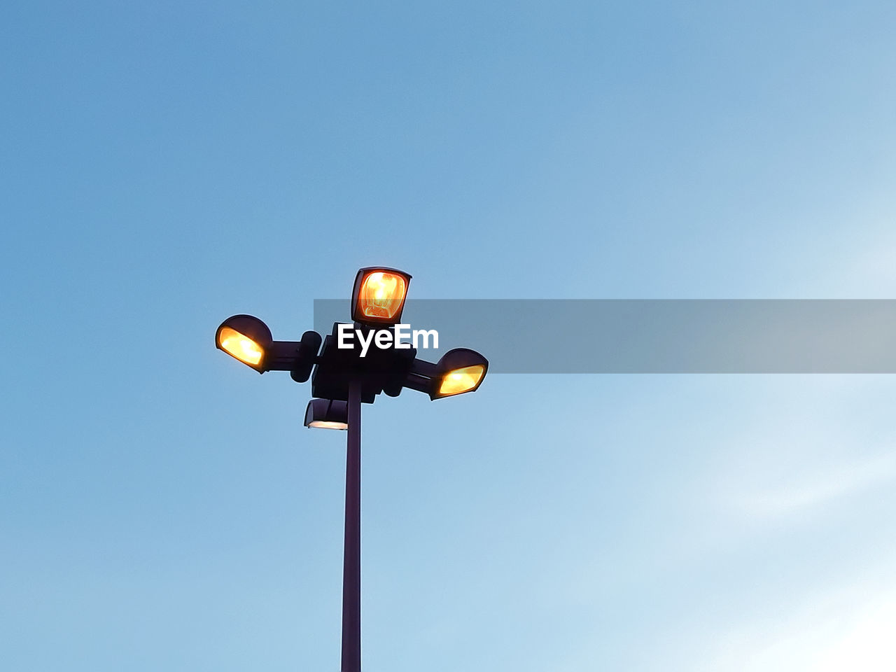 LOW ANGLE VIEW OF ILLUMINATED STREET LIGHT AGAINST SKY