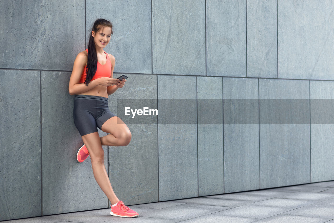 Young woman using mobile phone in city