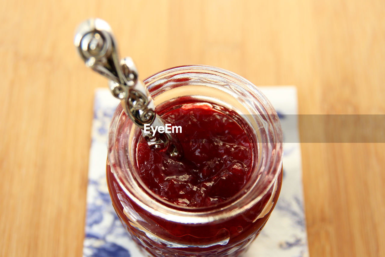 High angle view of strawberry jam in glass jar on table