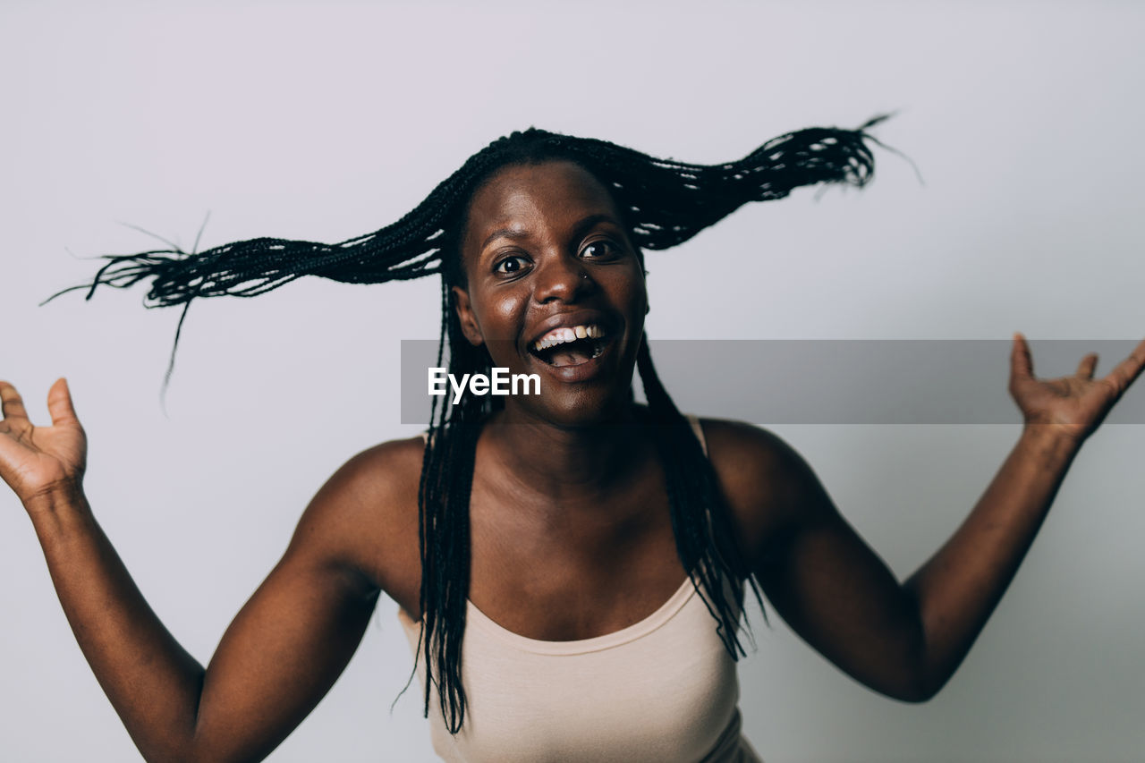 Portrait of happy young woman against gray background