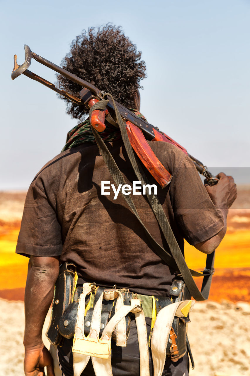 Rear view of terrorist holding rifle