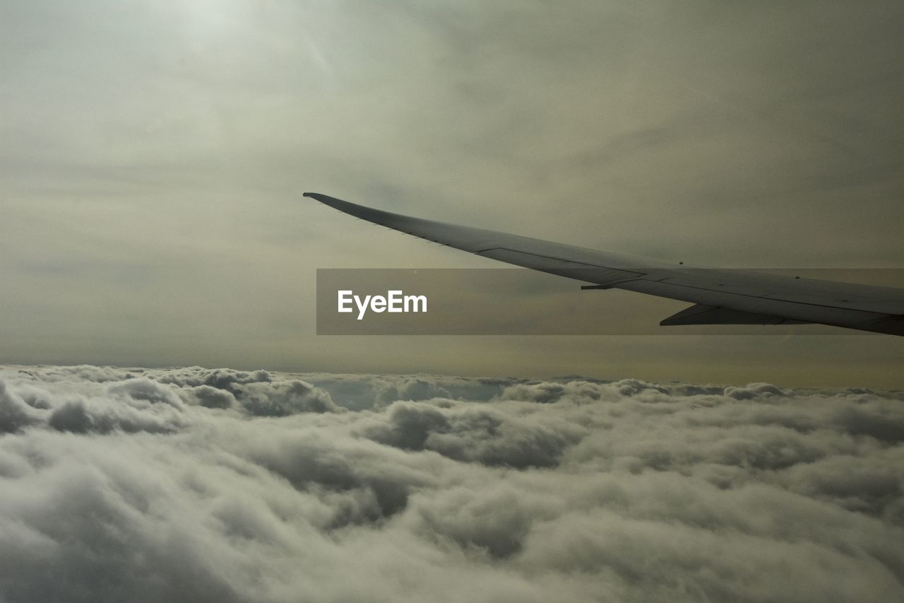 AIRPLANE WING OVER CLOUDSCAPE