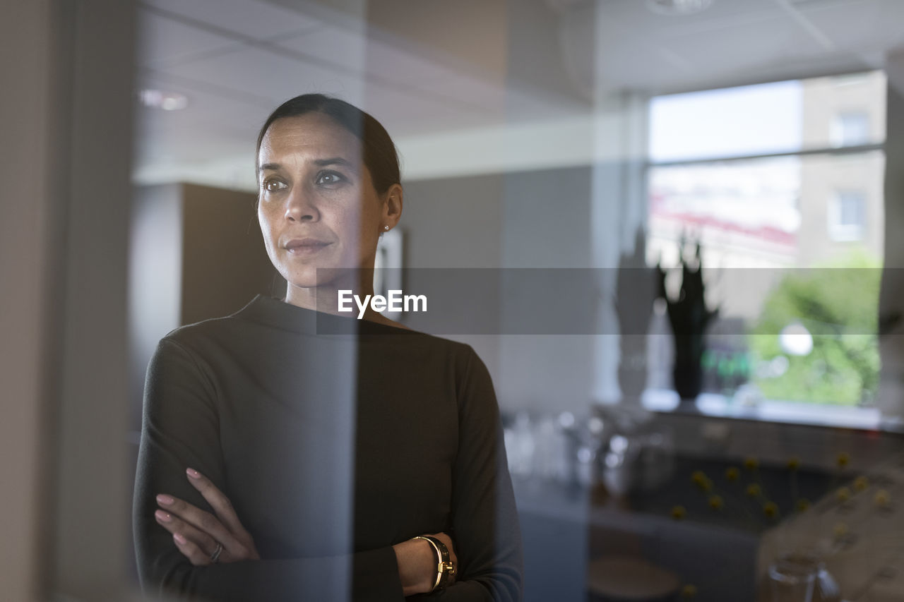 Businesswoman in office looking through window