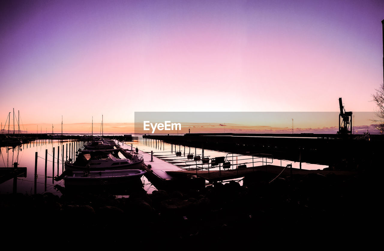 BOATS MOORED AT HARBOR AGAINST SKY