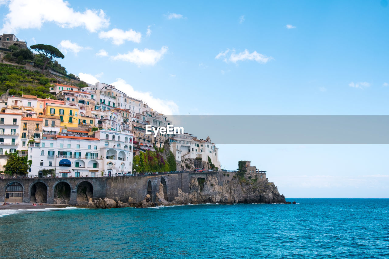 Scenic view of village on hill at mediterranean coastline