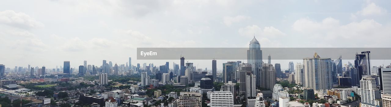 Panoramic view of modern buildings in city against sky