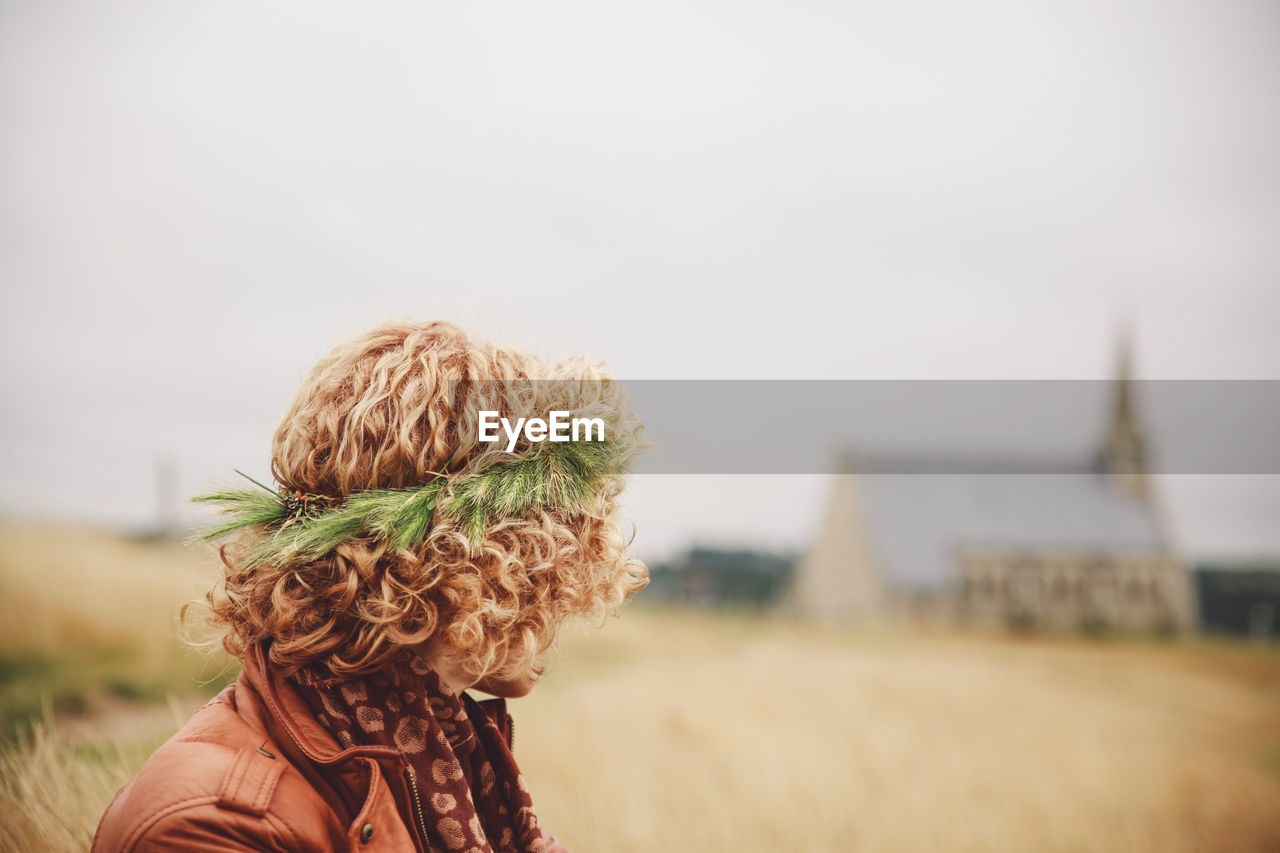 Close-up of woman on field against sky
