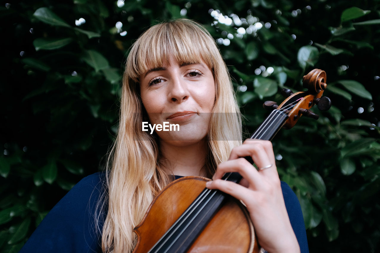 Portrait of smiling woman holding violin