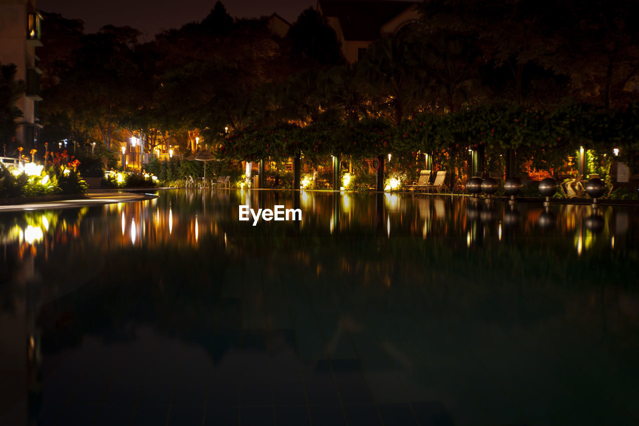 SCENIC VIEW OF LAKE AGAINST ILLUMINATED CITY AT NIGHT