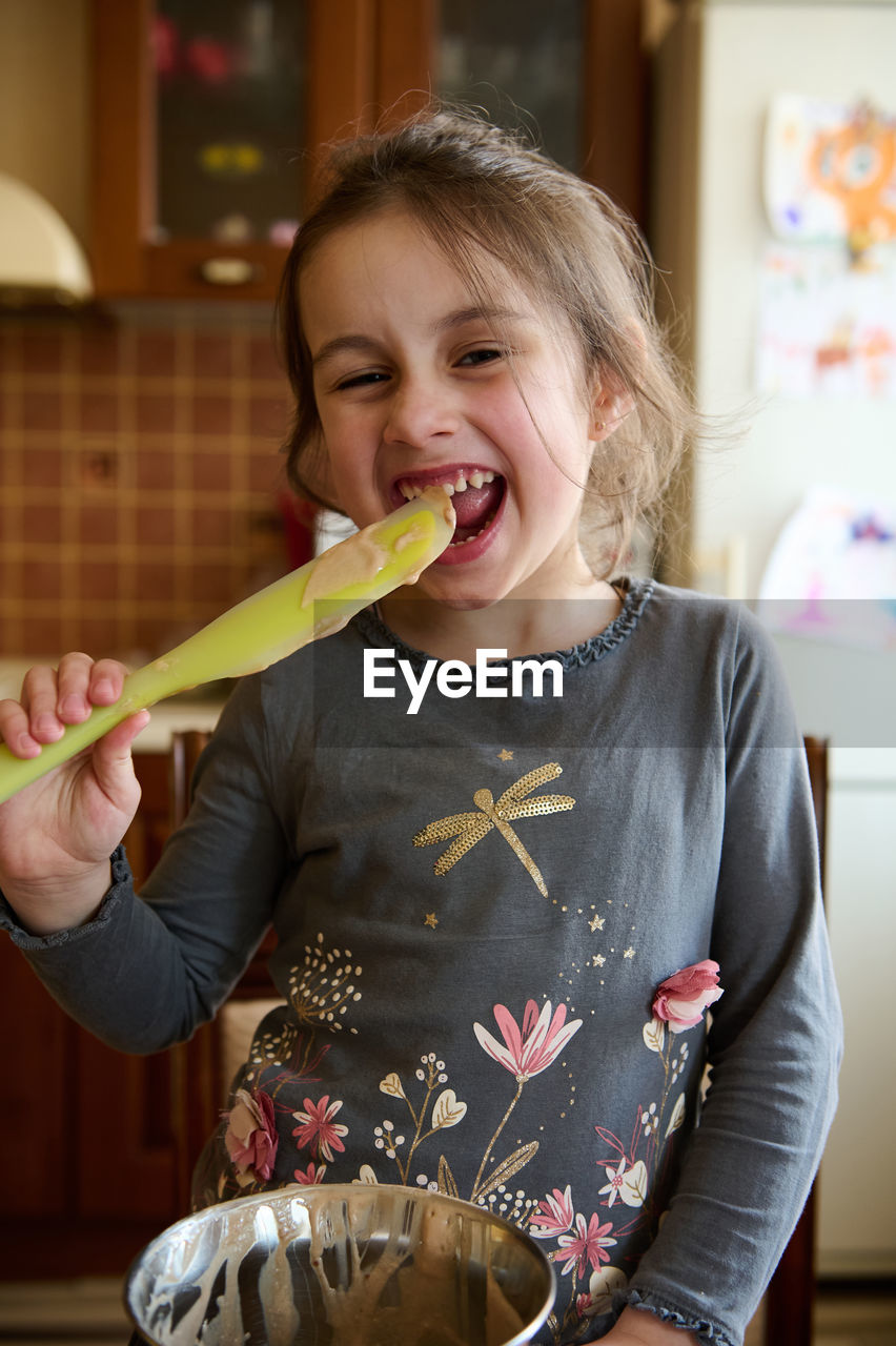 portrait of young woman eating food at home