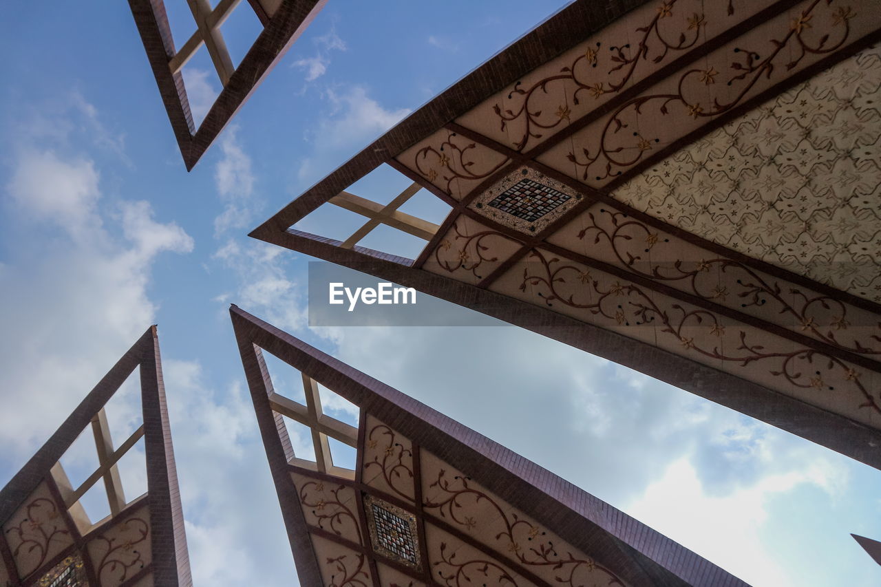 LOW ANGLE VIEW OF CROSS ON RAILING AGAINST SKY