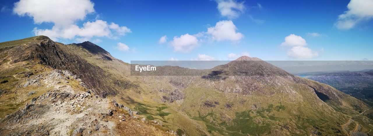 PANORAMIC VIEW OF MOUNTAINS AGAINST BLUE SKY