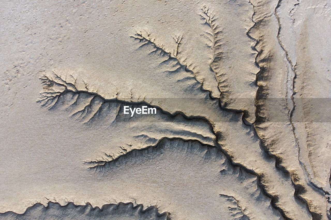 HIGH ANGLE VIEW OF FOOTPRINT ON SAND