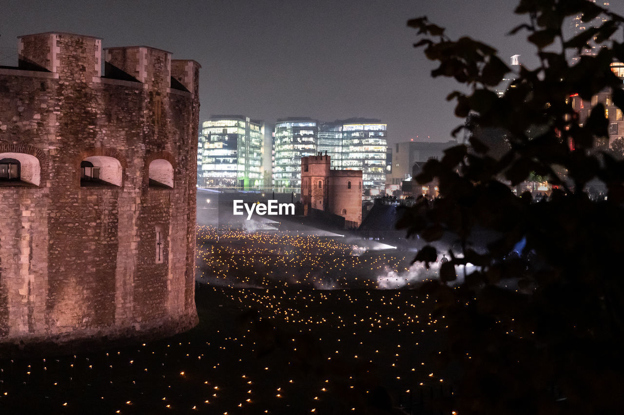 ILLUMINATED BUILDINGS SEEN THROUGH WET WINDOW