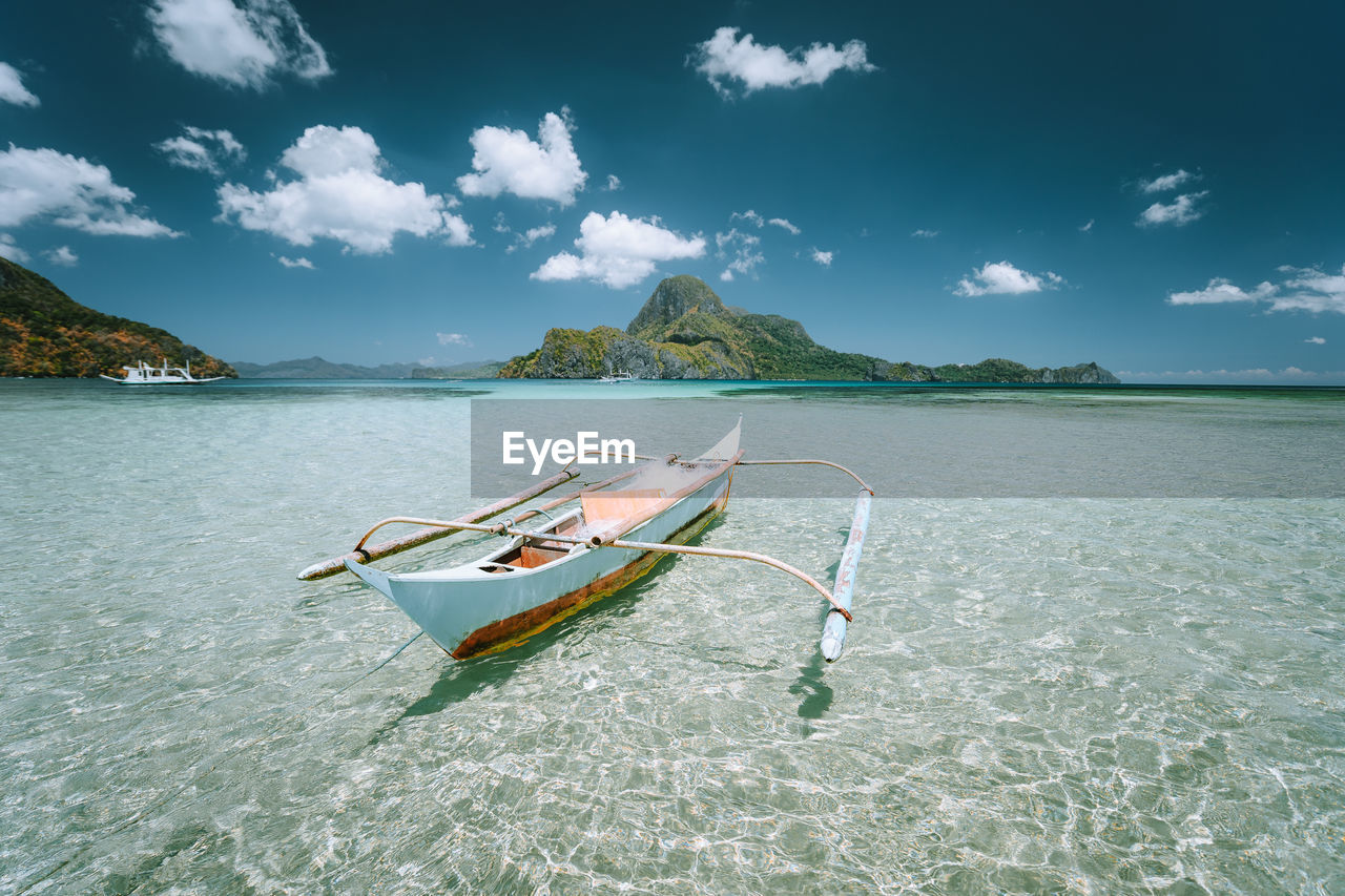 Boat moored in sea against sky