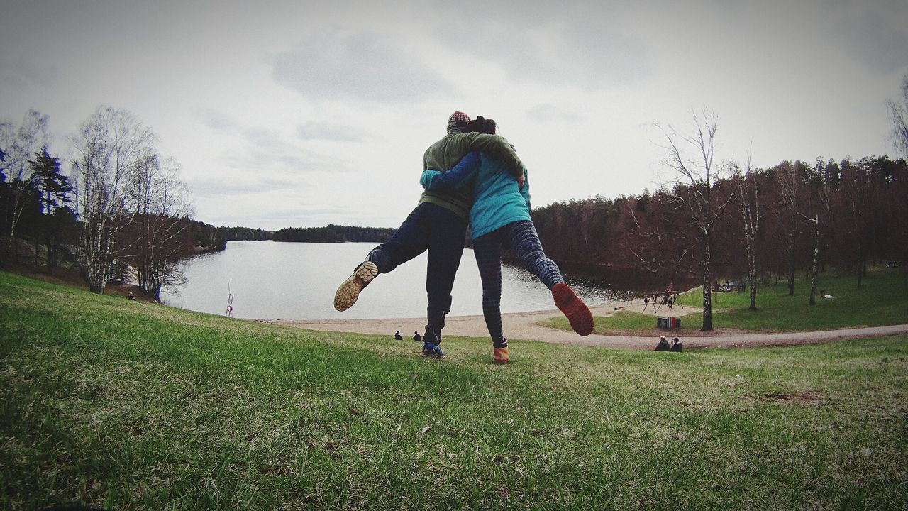 Rear view of couple overlooking calm lake