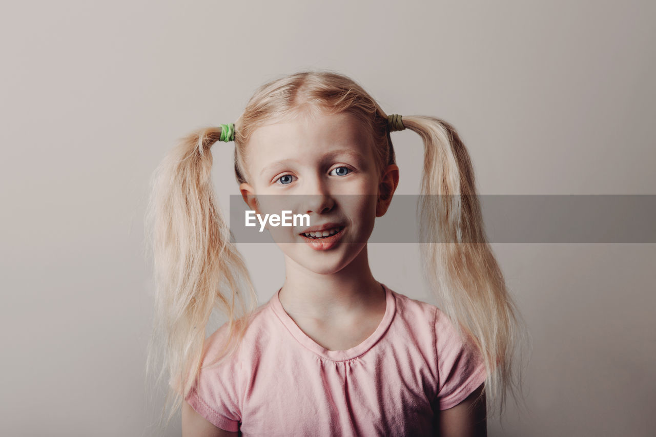 Portrait of smiling girl against colored background