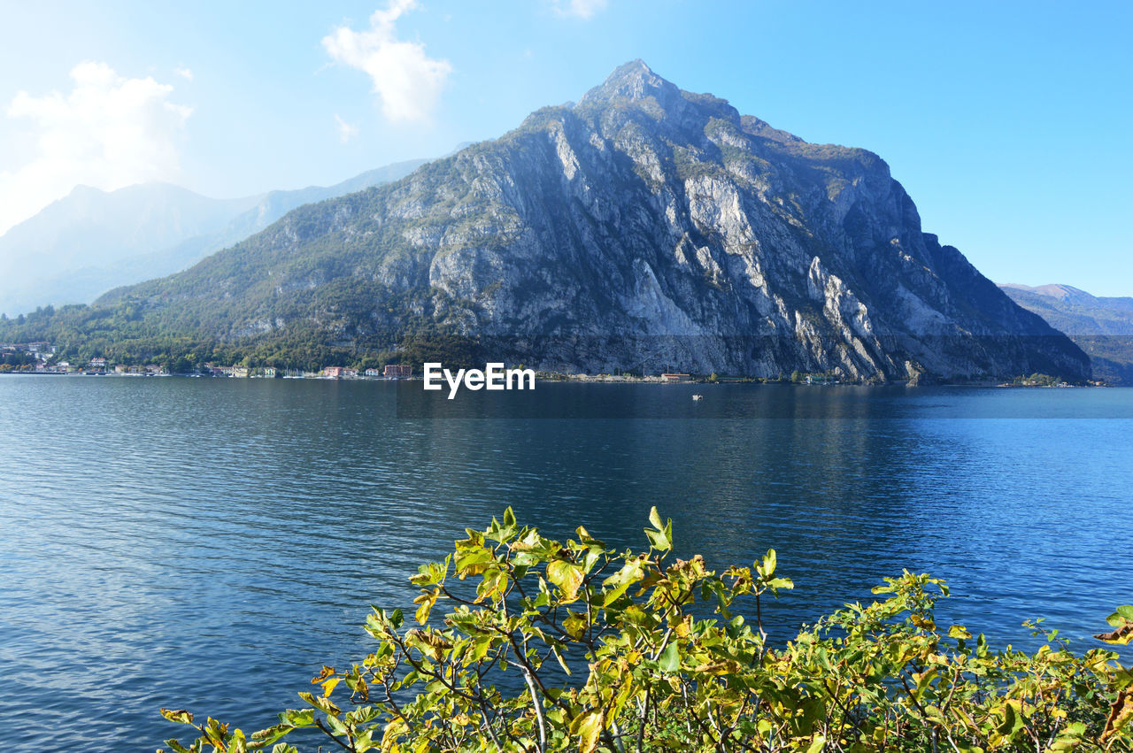 Scenic view of lake by mountains against sky