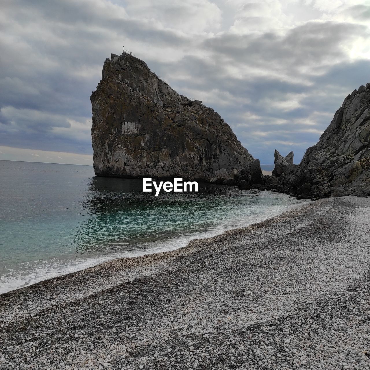 SCENIC VIEW OF ROCKS ON SHORE AGAINST SKY