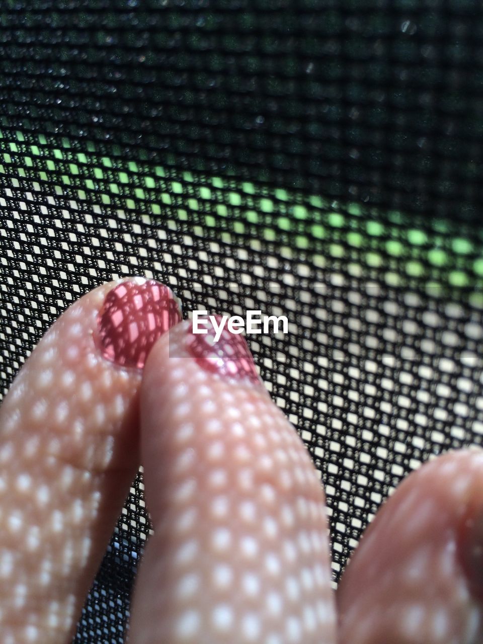 Close-up of woman fingers by net