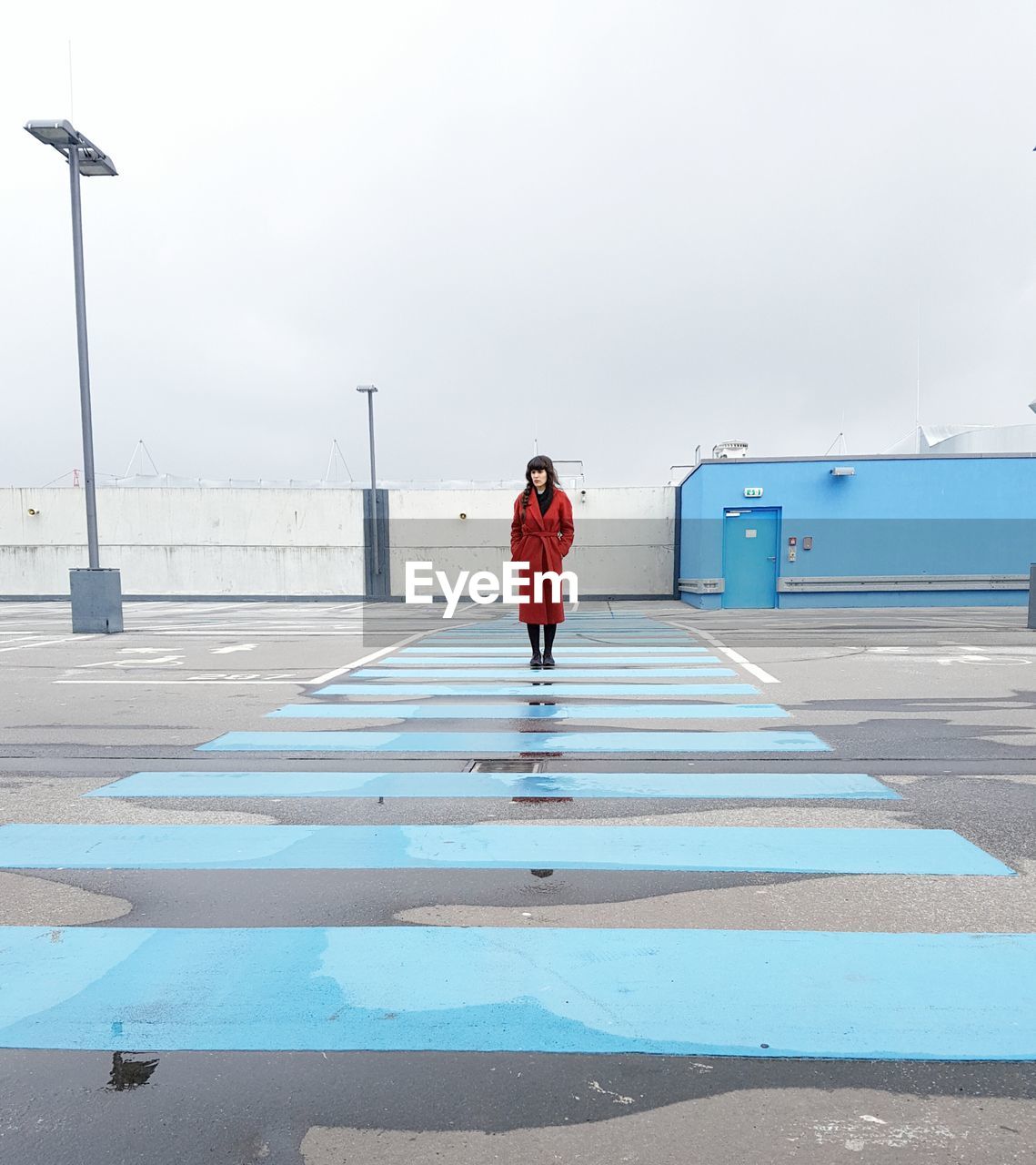 REAR VIEW OF WOMAN STANDING ON ROAD