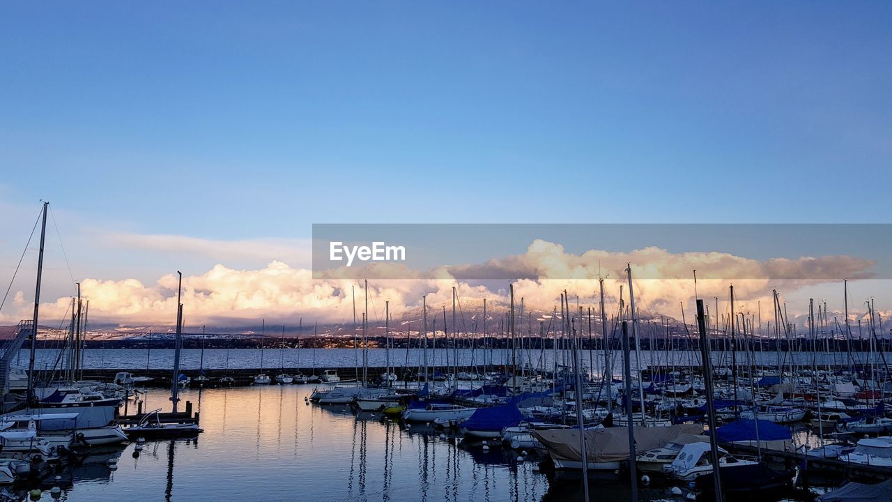 BOATS MOORED IN HARBOR AT DUSK