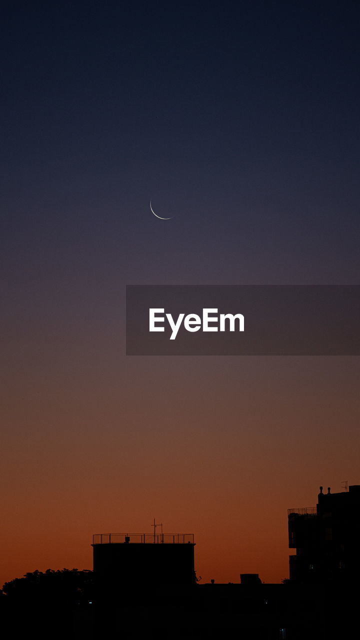 SILHOUETTE BUILDINGS AGAINST CLEAR SKY AT SUNSET