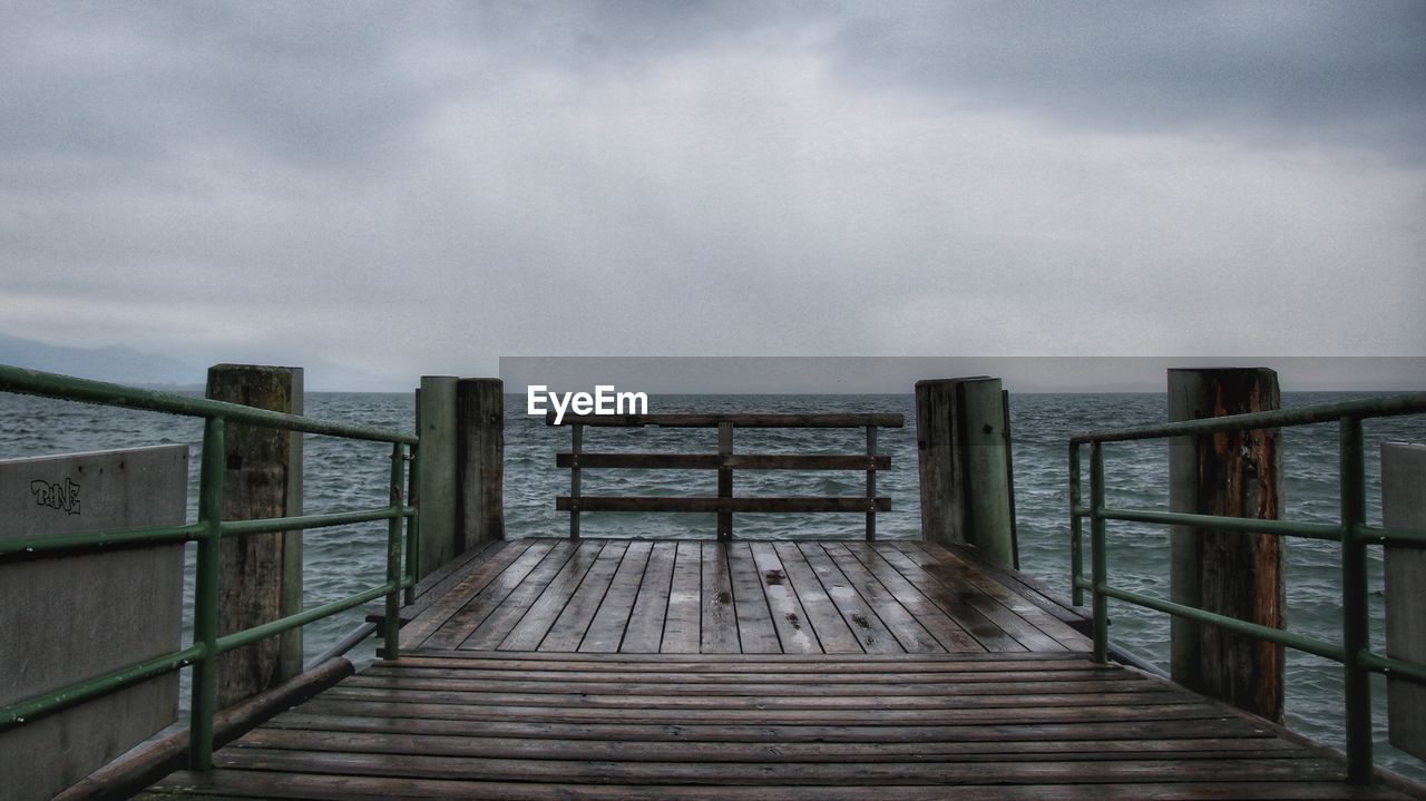 Wooden pier over sea against sky