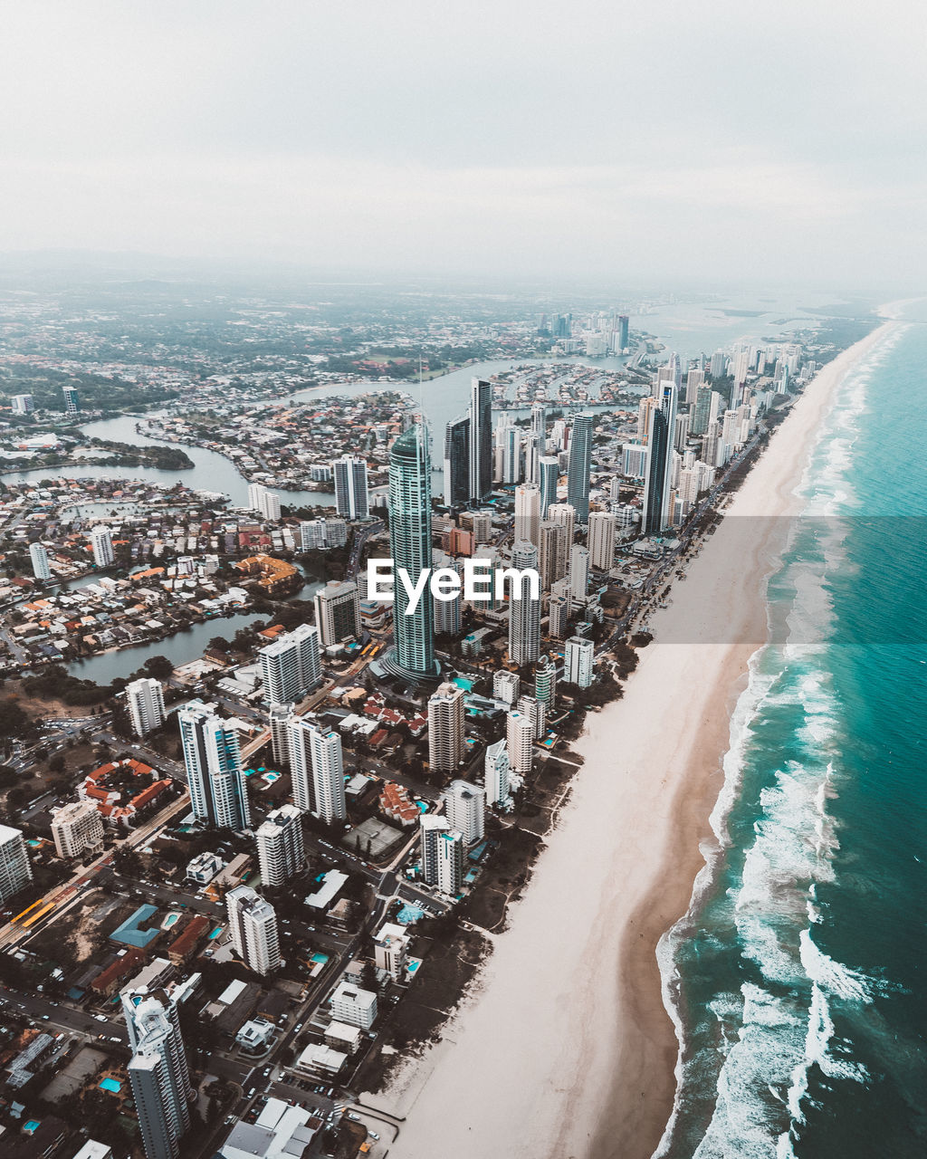 Aerial view of sea and cityscape against sky