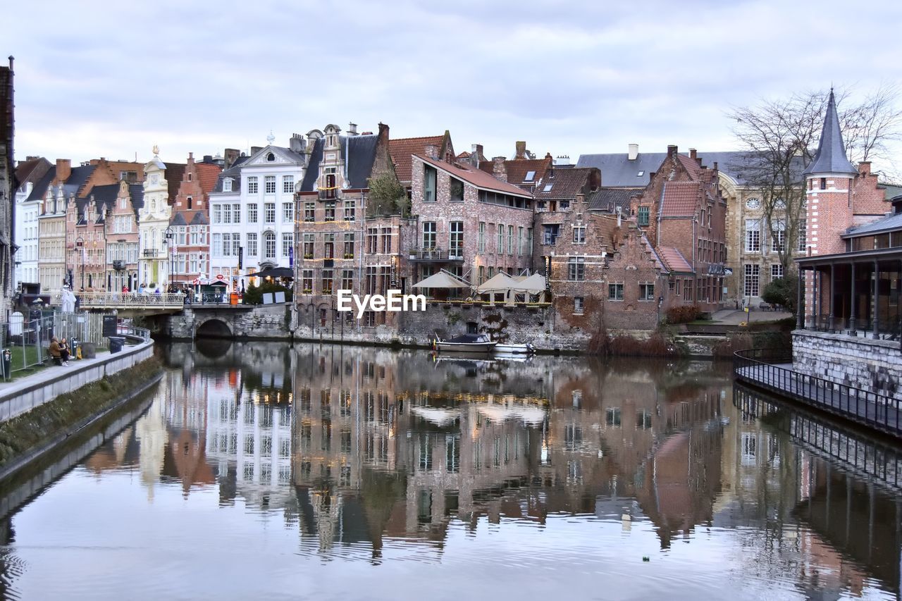 Reflection of buildings in city against sky