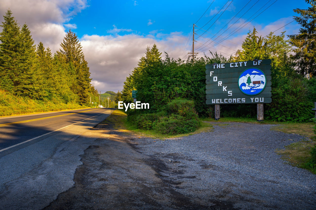 road, sign, sky, tree, plant, cloud, transportation, road sign, nature, communication, symbol, no people, blue, guidance, street, landscape, city, environment, the way forward, outdoors, day, land, text, information sign