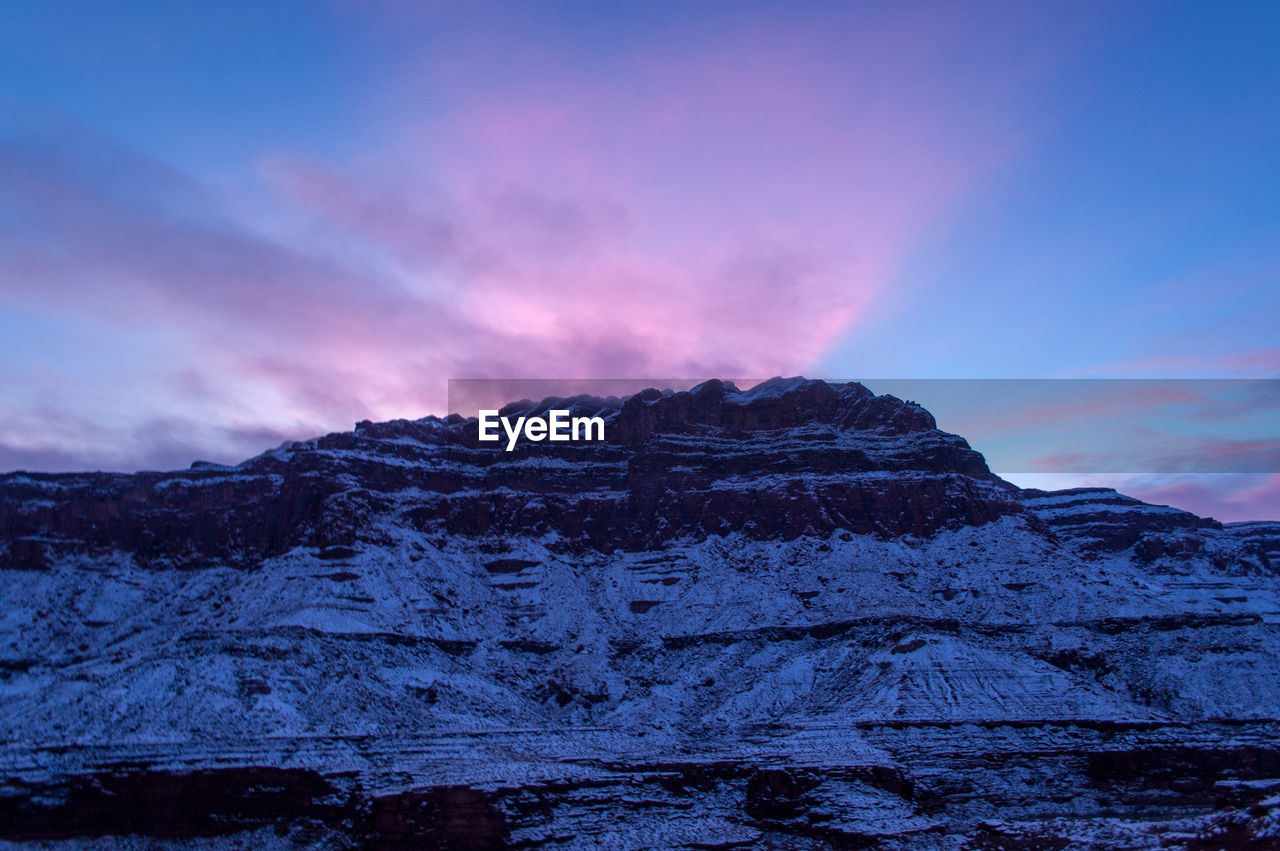 Scenic view of snowcapped mountains against sky during sunset