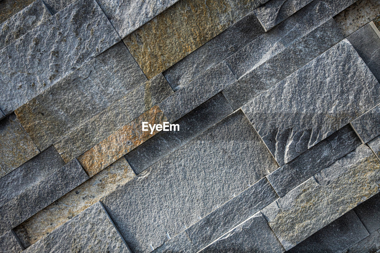 Background of gray and brown stone wall made with blocks . pattern of slate wall texture 