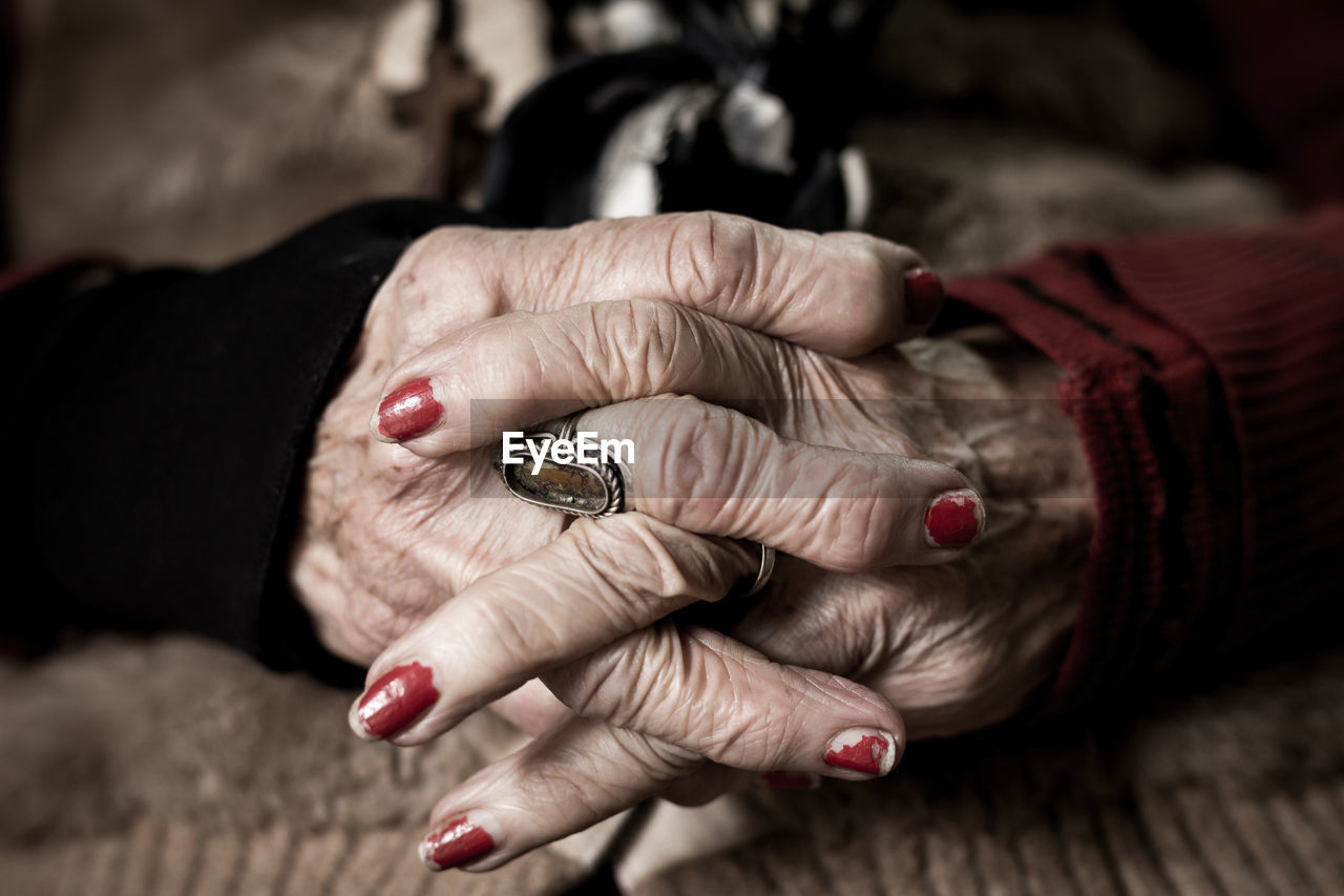 Cropped image of senior friends with holding hands on table