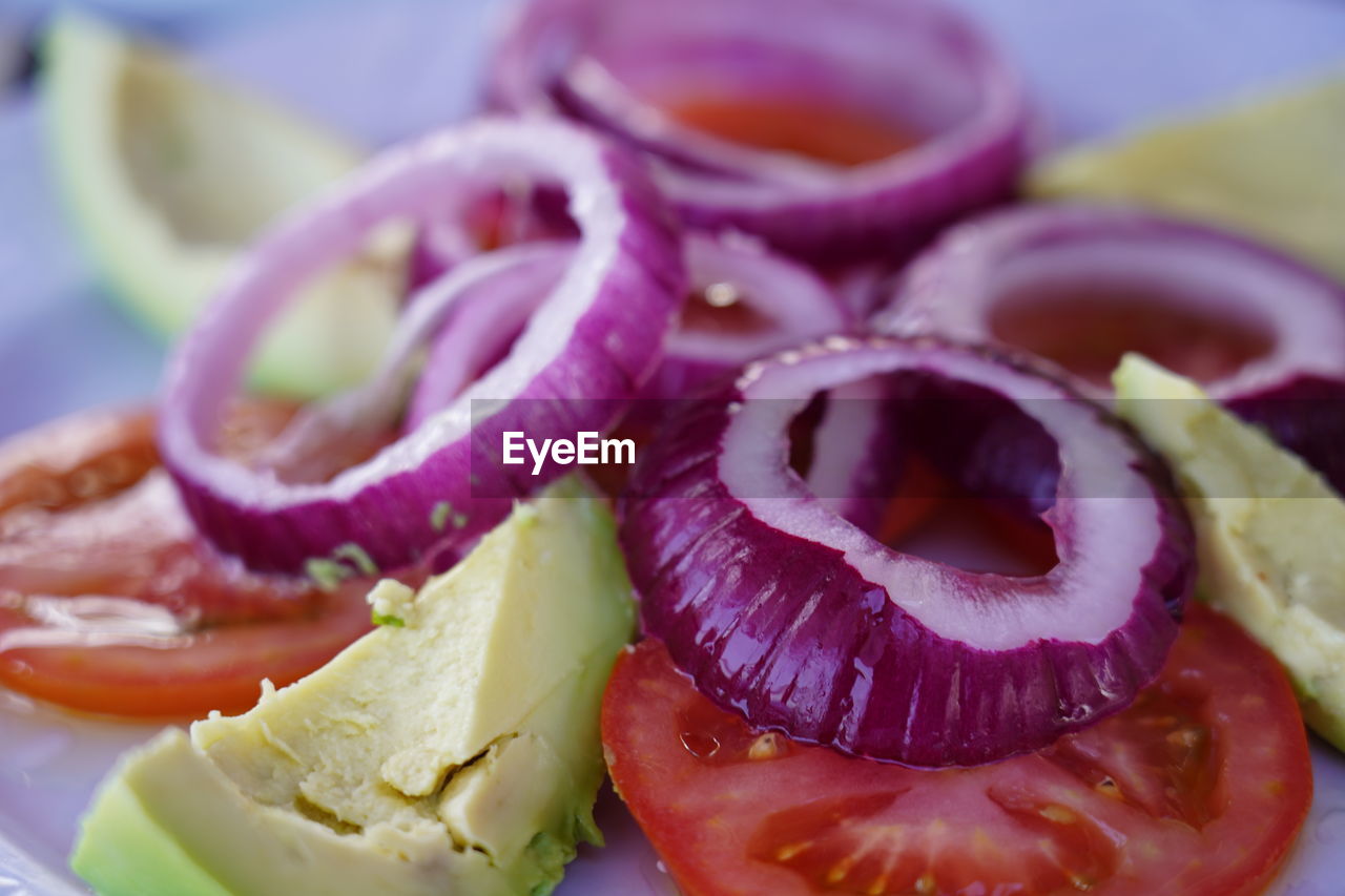 Raw vegan salad of fresh onion rings, tomatoe and avocado slices, tenerife, canary islands