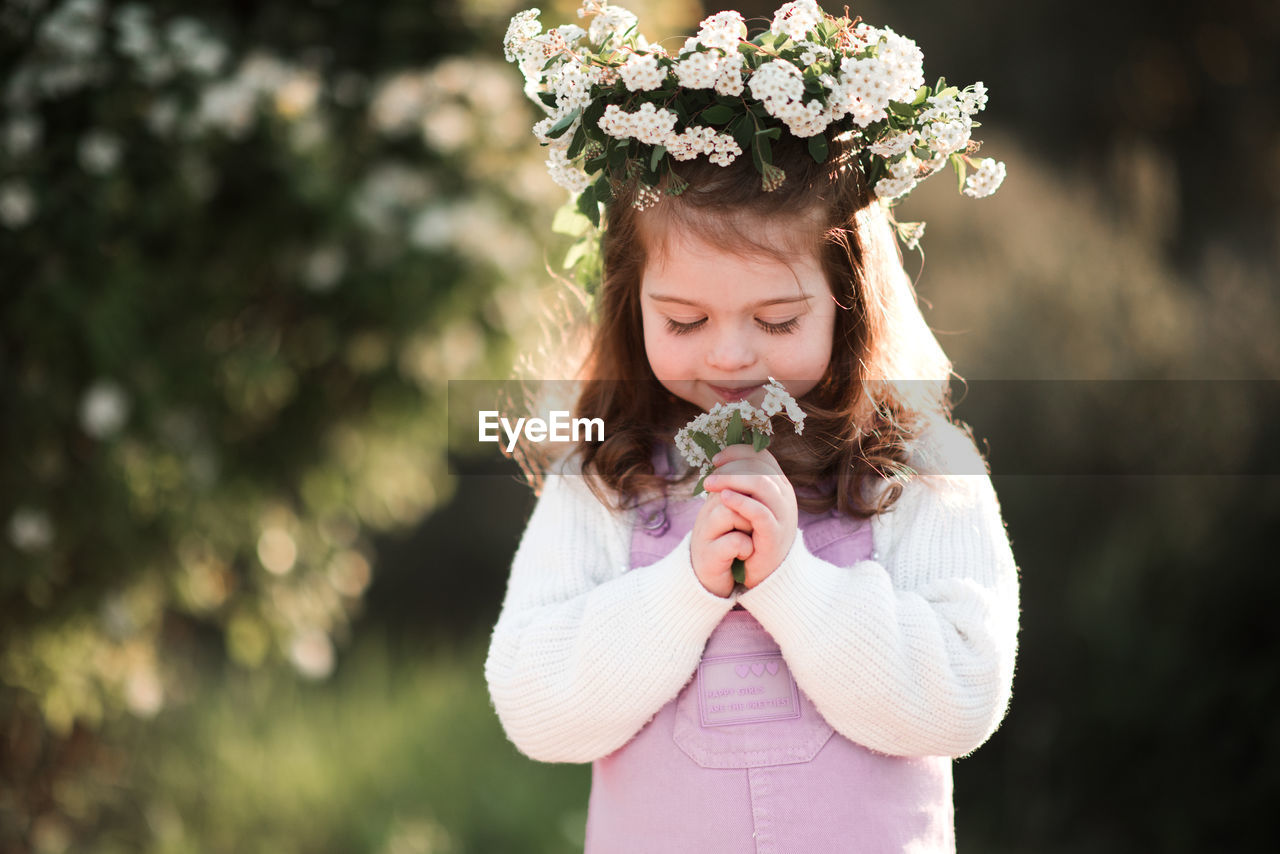 Cute girl smelling flowers in garden