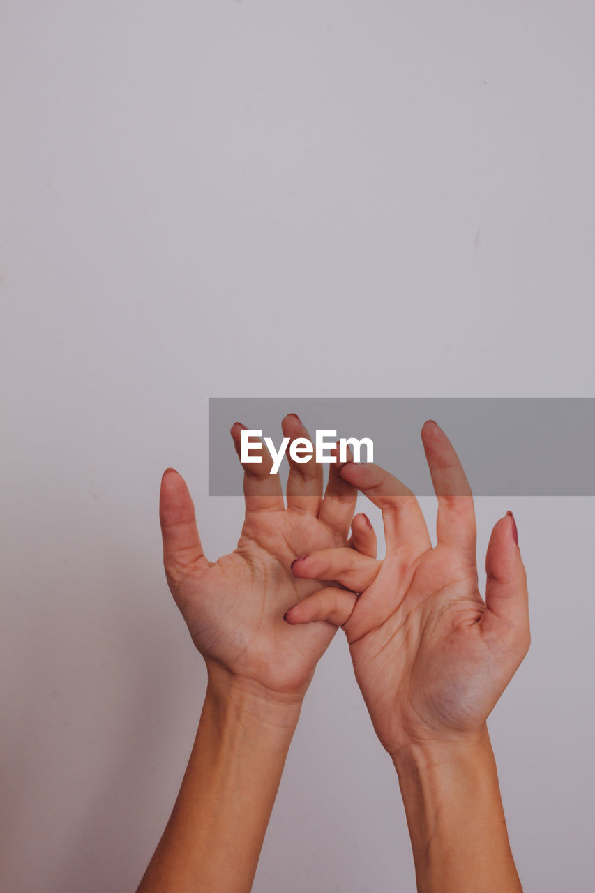 Close-up of hands over white background