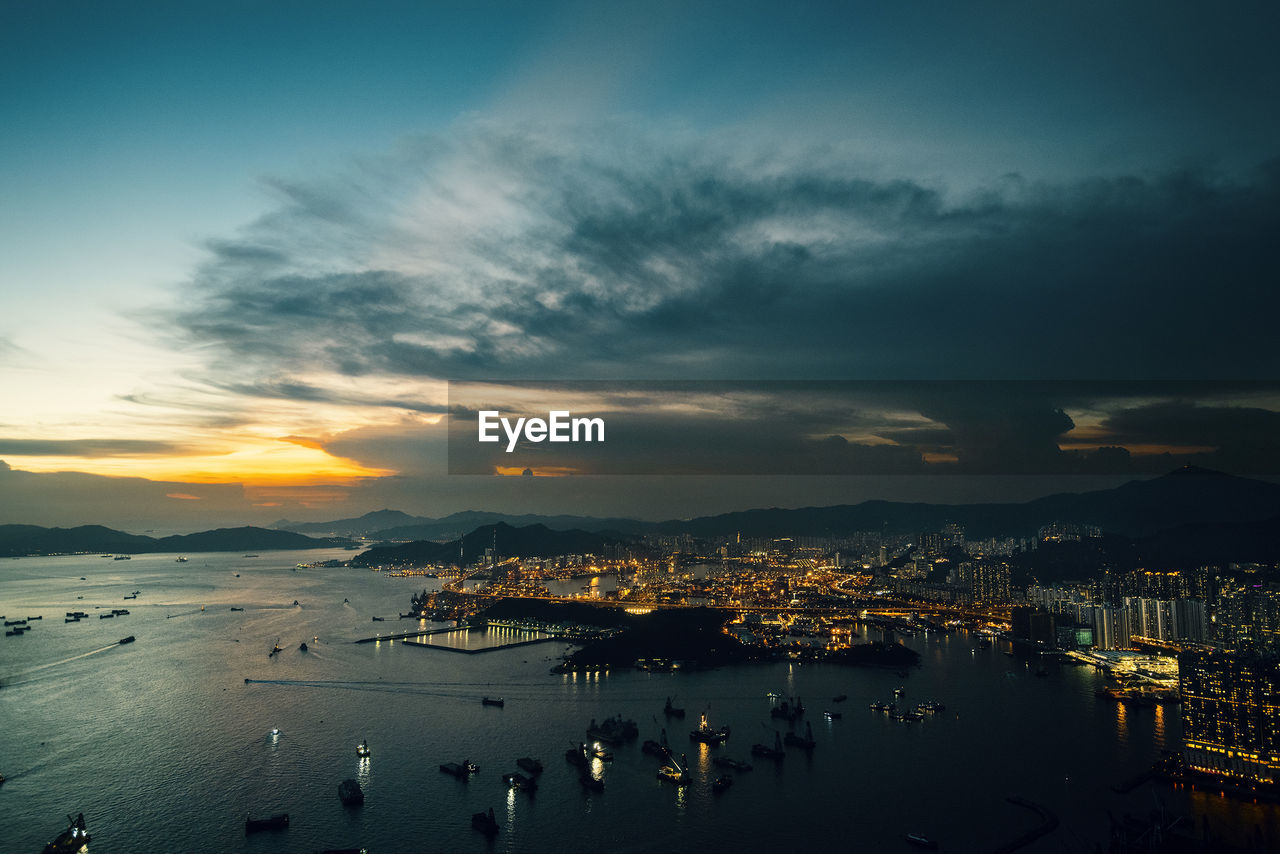 High angle view of illuminated cityscape against sky at sunset