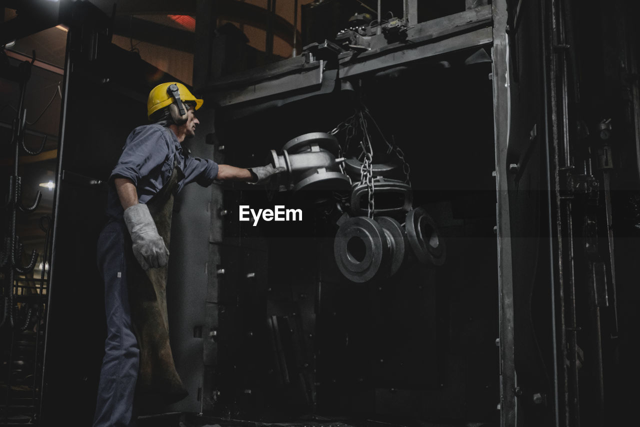 Man working over metallic machine in industry