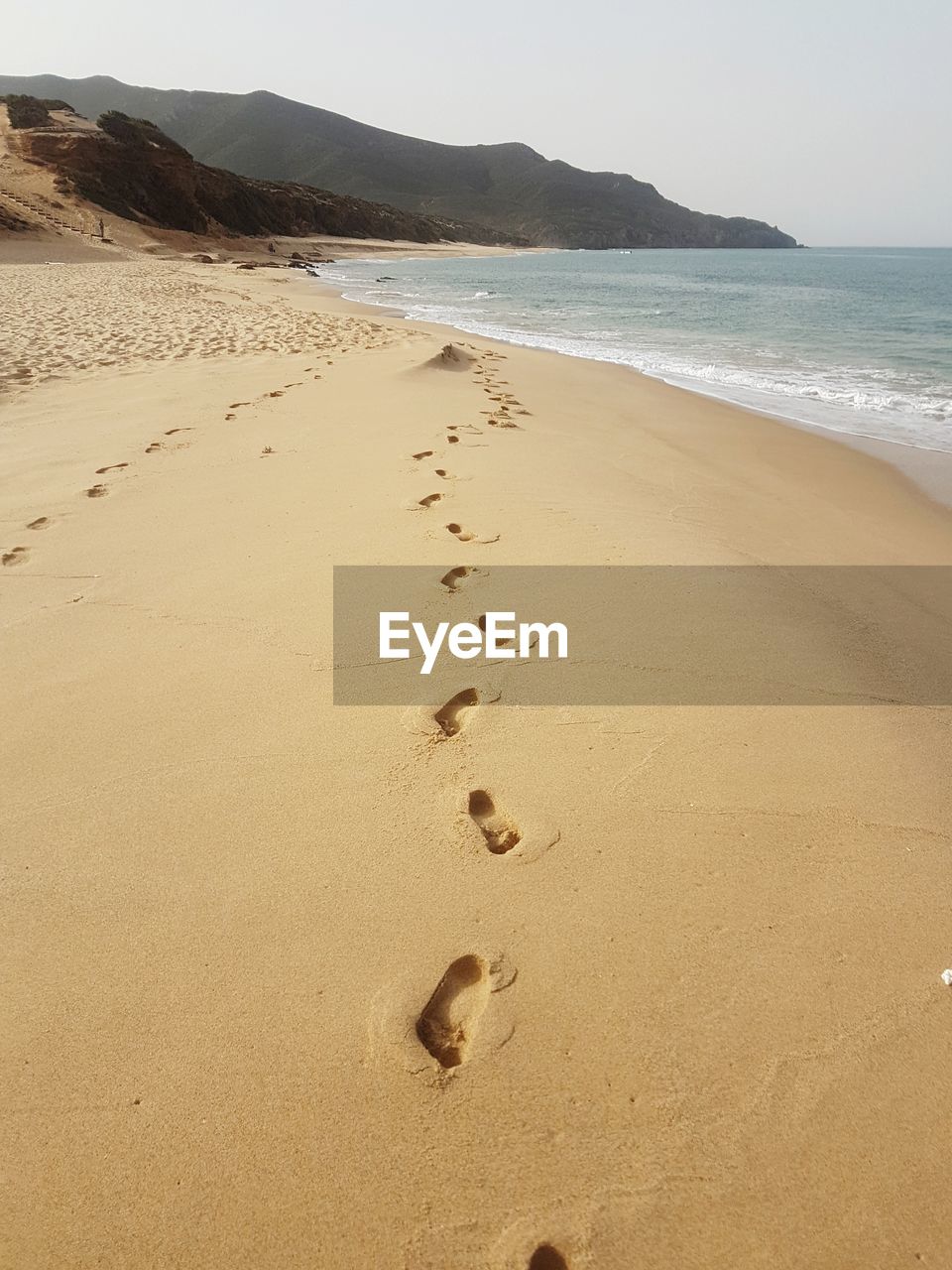 FOOTPRINTS ON SANDY BEACH AGAINST SKY