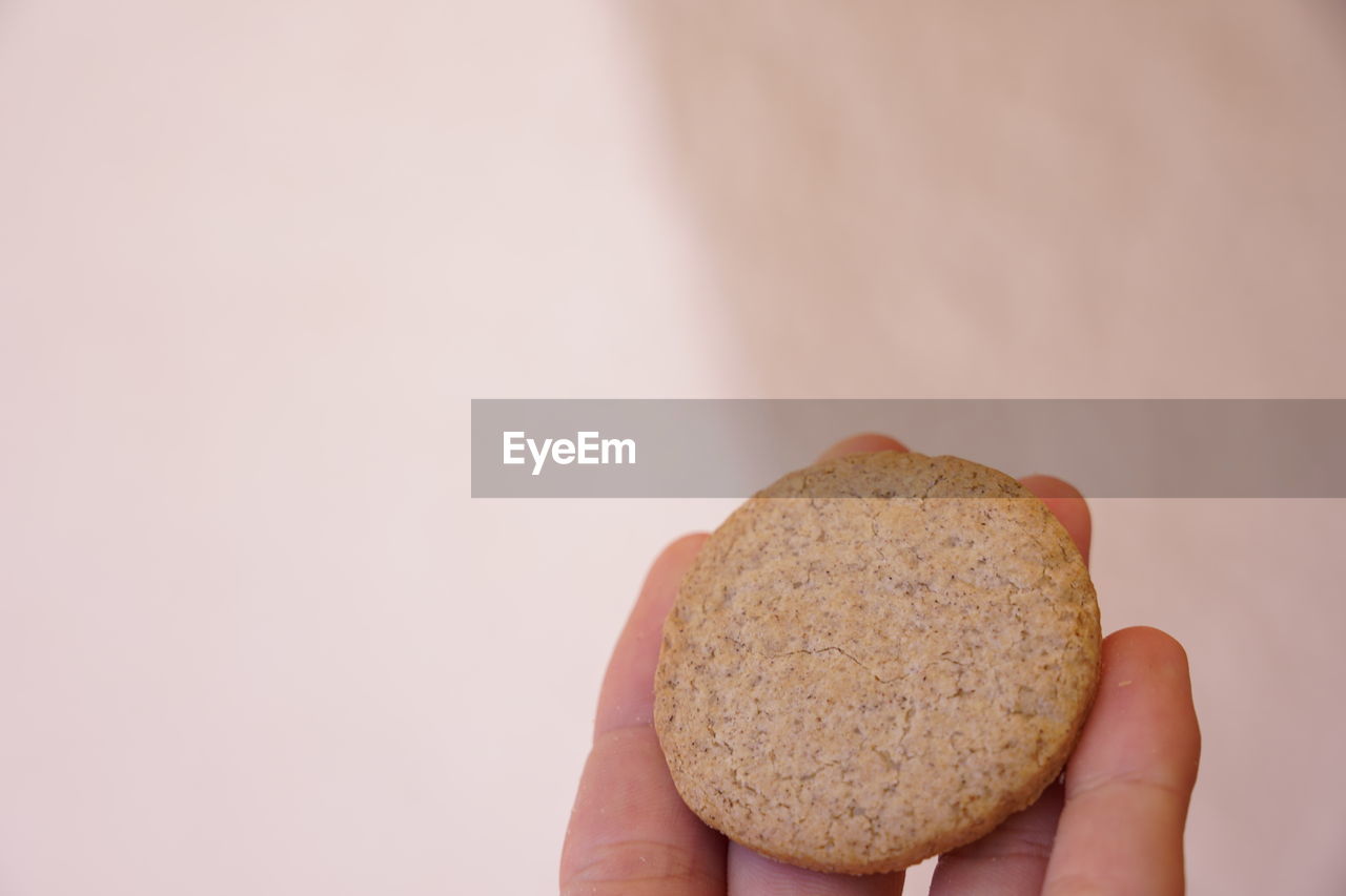 CLOSE-UP OF HAND HOLDING BREAD